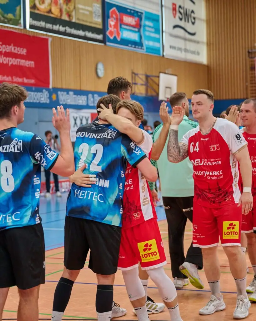 Spieler des Stralsunder HV und des THW Kiel klatschen nach dem Spiel ab und umarmen sich