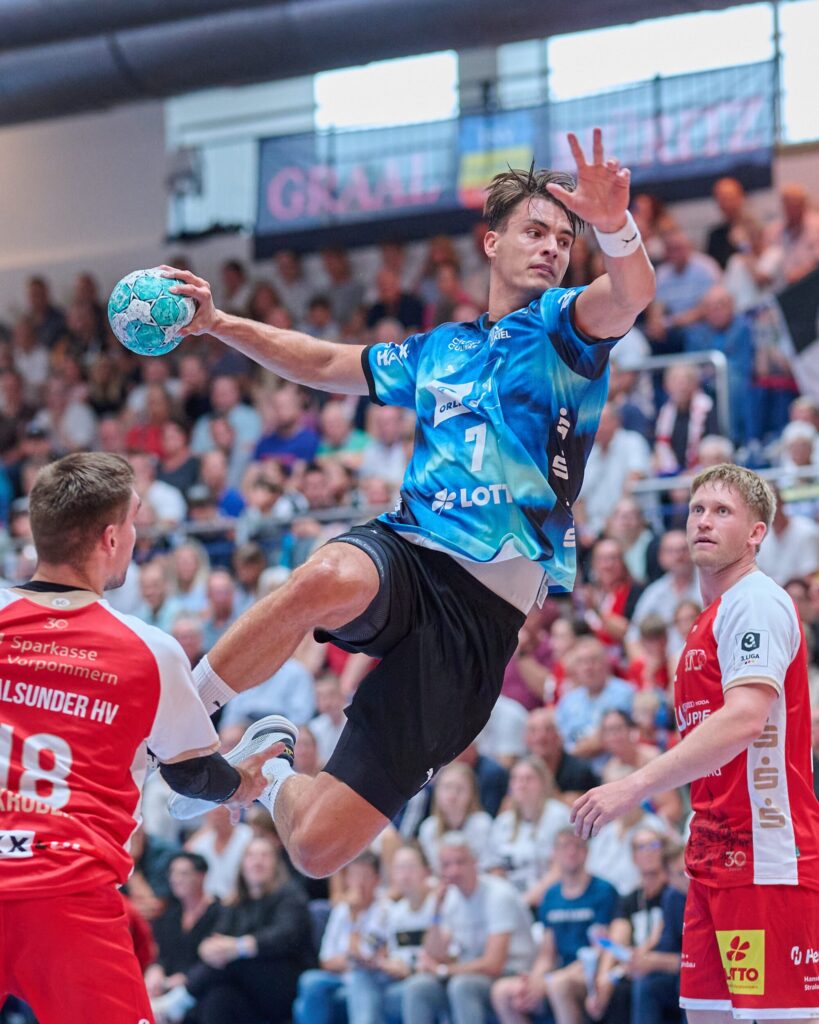 THW-Kiel-Spieler zieht zum Sprungwurf gegen die Abwehr des Stralsunder HV